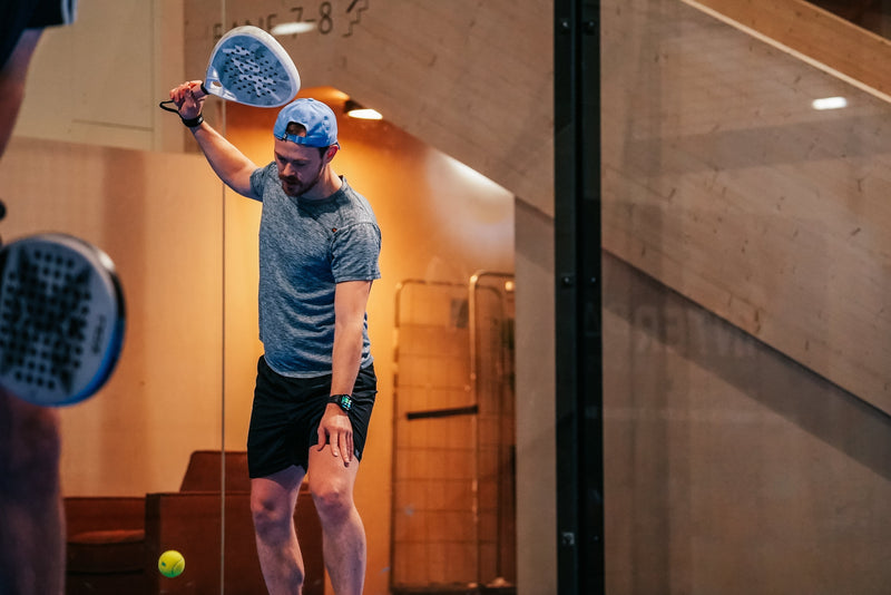 Padel player serving on court with a 12K Padel racket