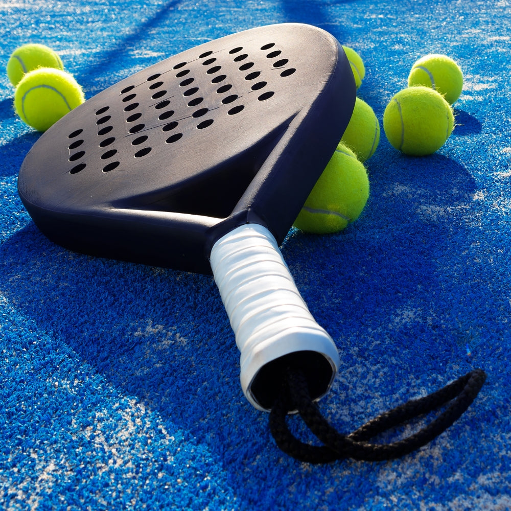 Padel player on a floodlit court at night
