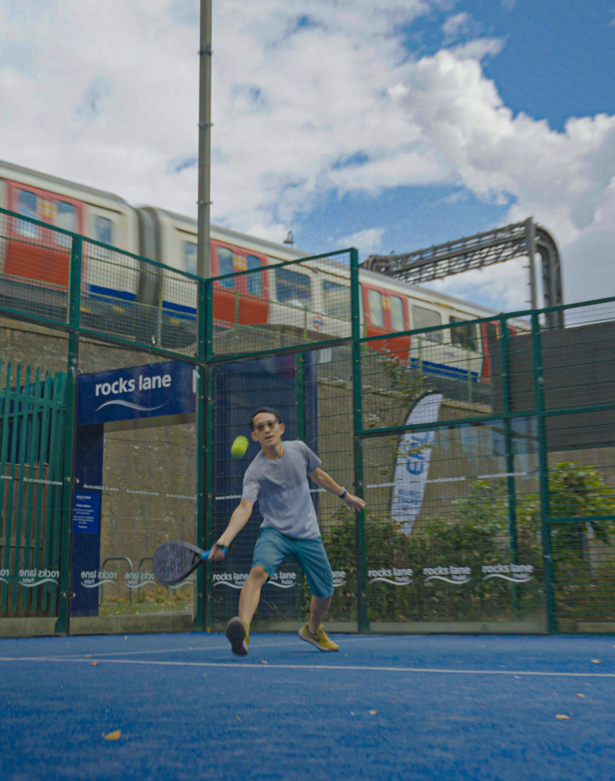 Padel court in London with a tube train passing behind the glass, where 12k Padel rackets are played