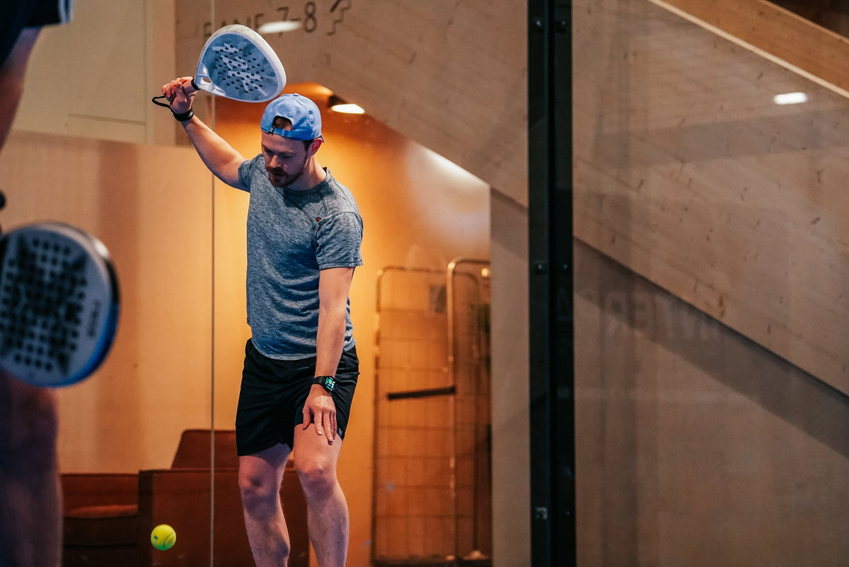 Padel player serving on court with a 12K Padel racket