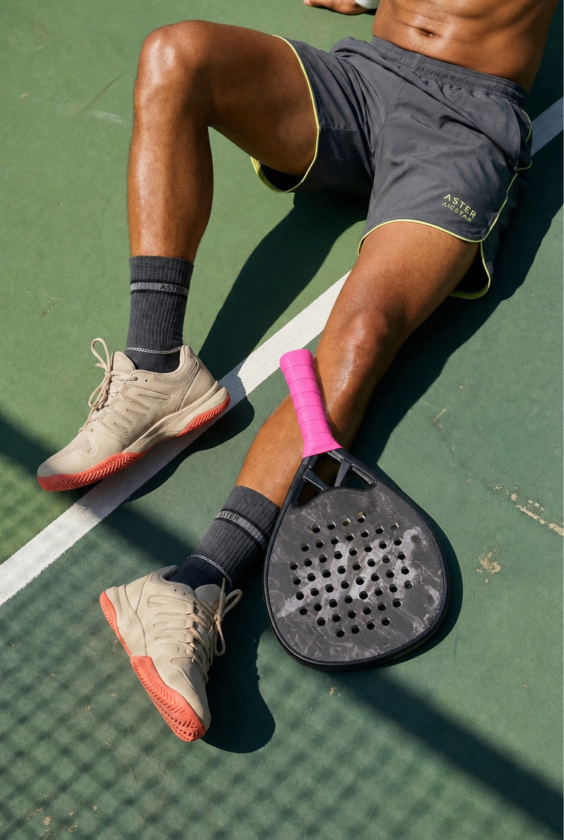 Padel player hitting a low half volley shot at the net during a match